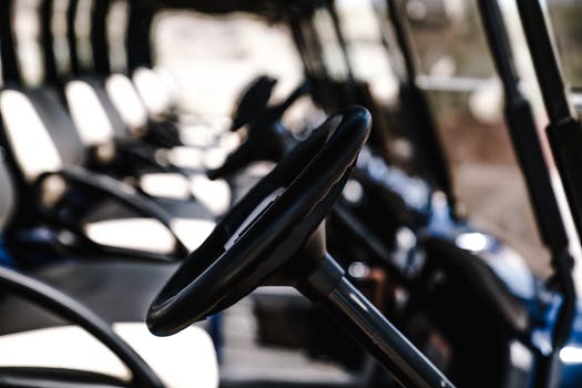 Close up of the wheels of single seater golf buggies in a row.